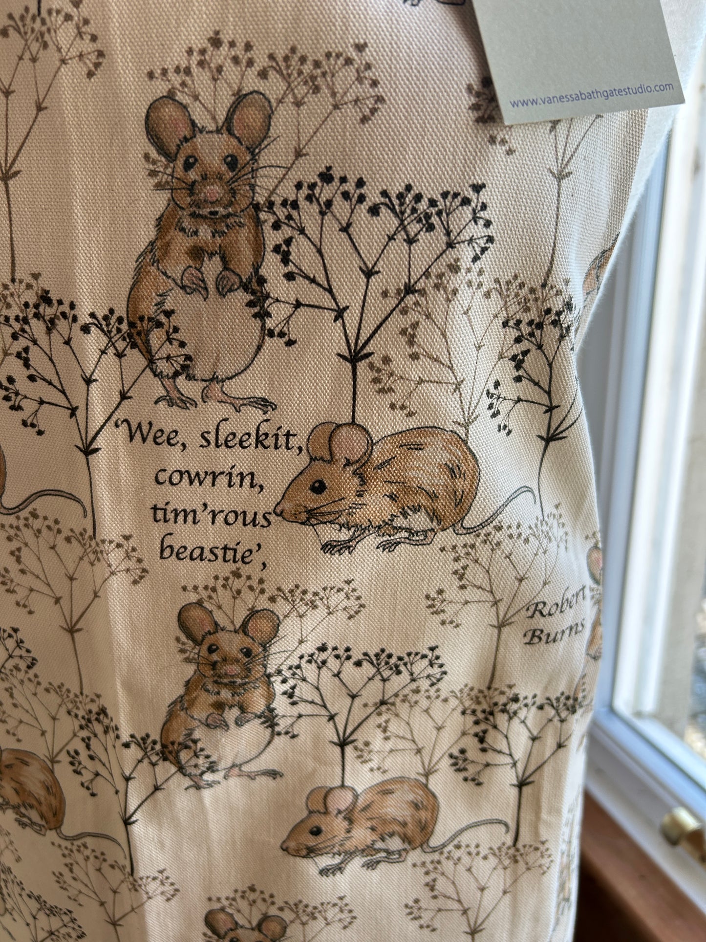Close up detail of Robert Burns quote on a cotton apron with mice illustrations