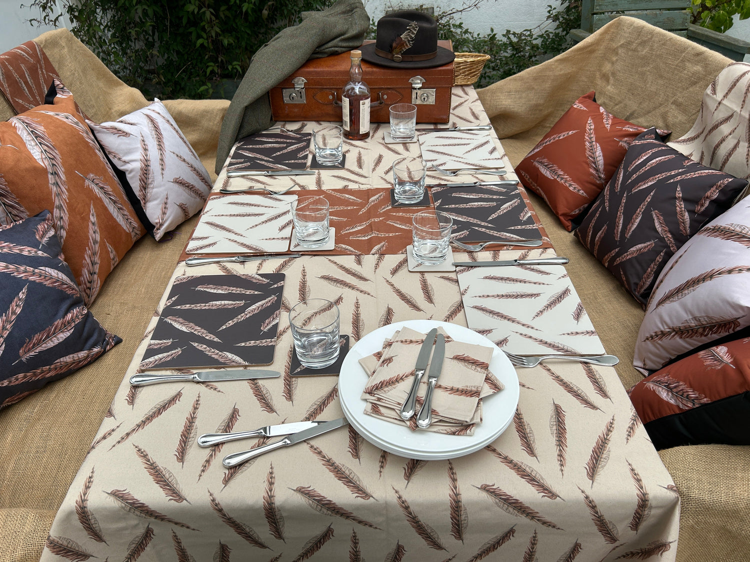 Outdoor table setting using feather design linen and place settings, pheasant feather design outdoor cushions. Country picnic table