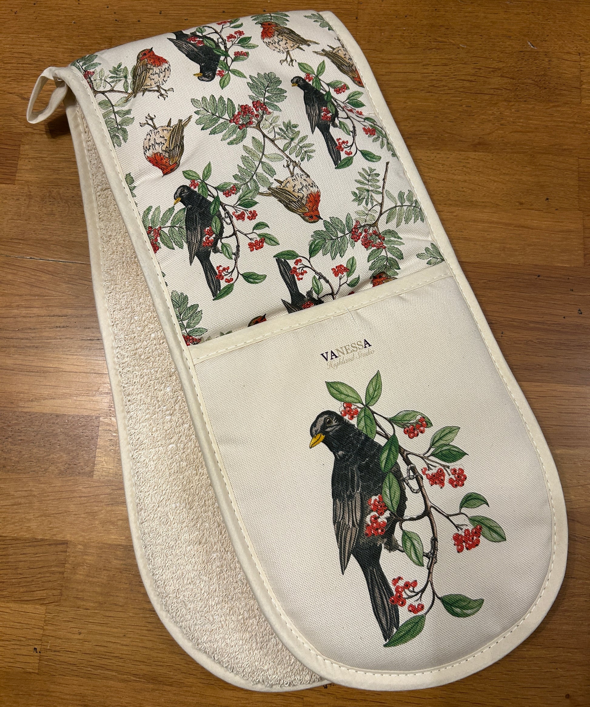 Blackbird berry illustration on a cream oven glove with Robins and Rowan berries prin on inner.