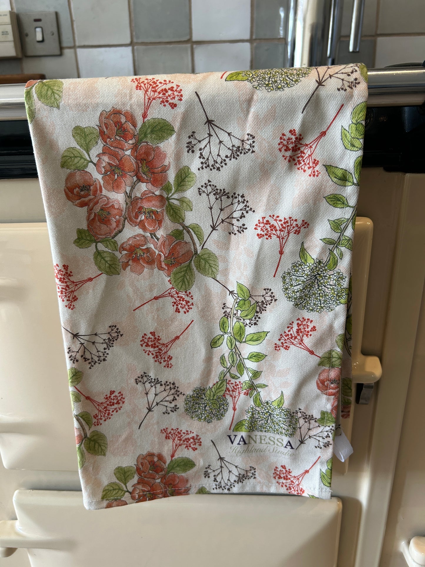Floral-patterned towel hanging on a stove rail 