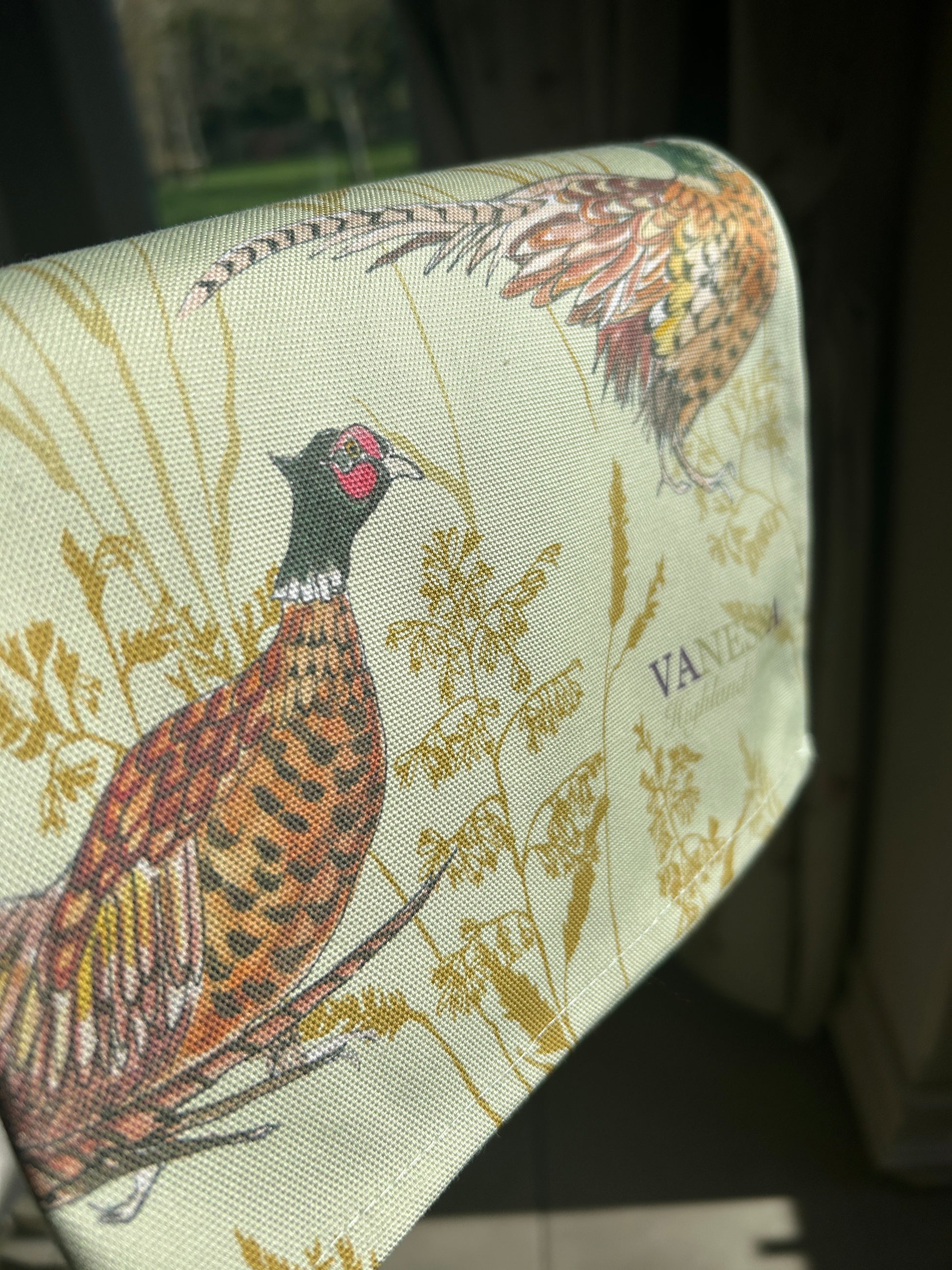 Close up of mint green tea towel with pheasant illustration