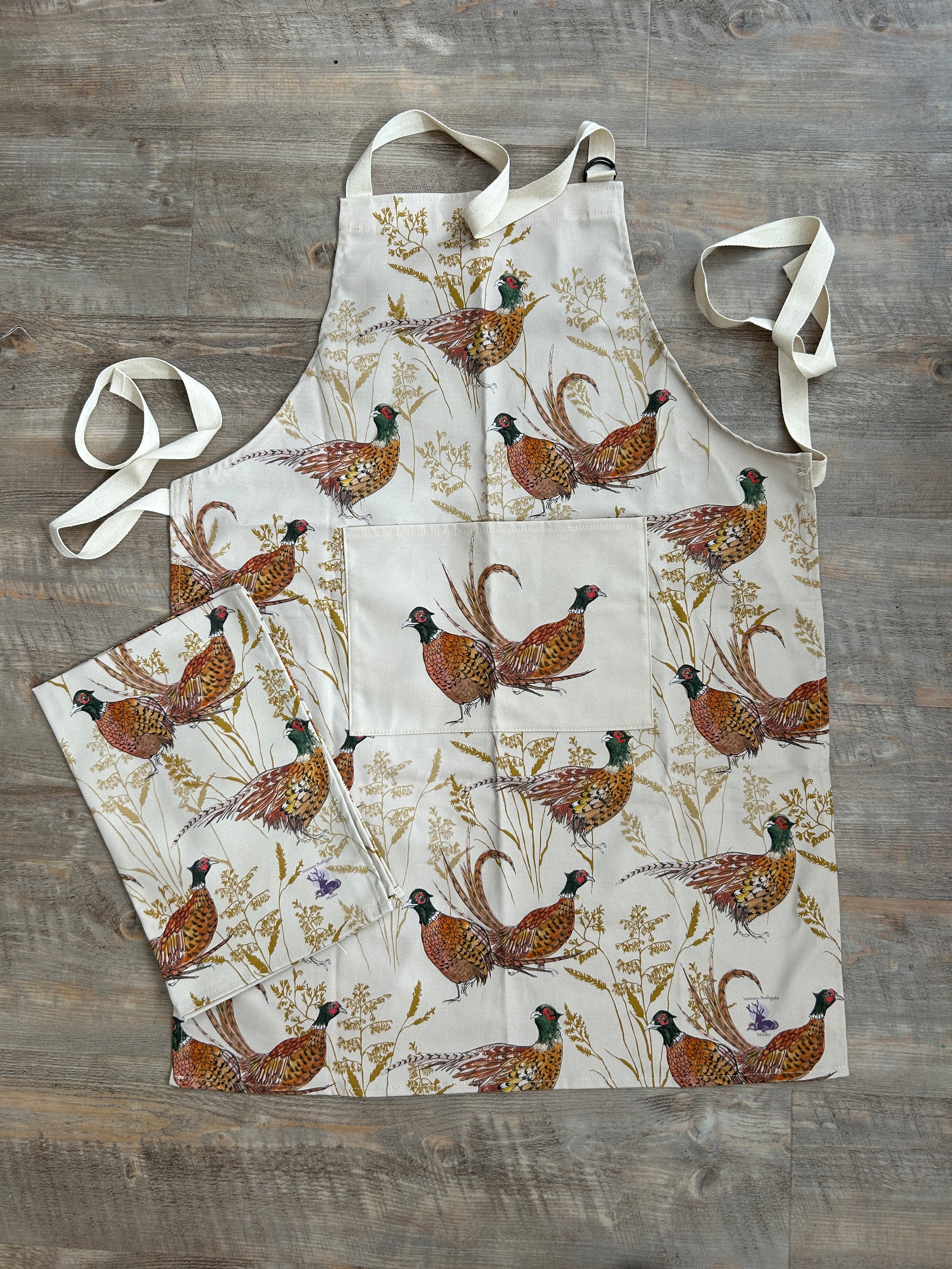 Pheasant and grass design apron with deep pocket on beige background. matching tea towel