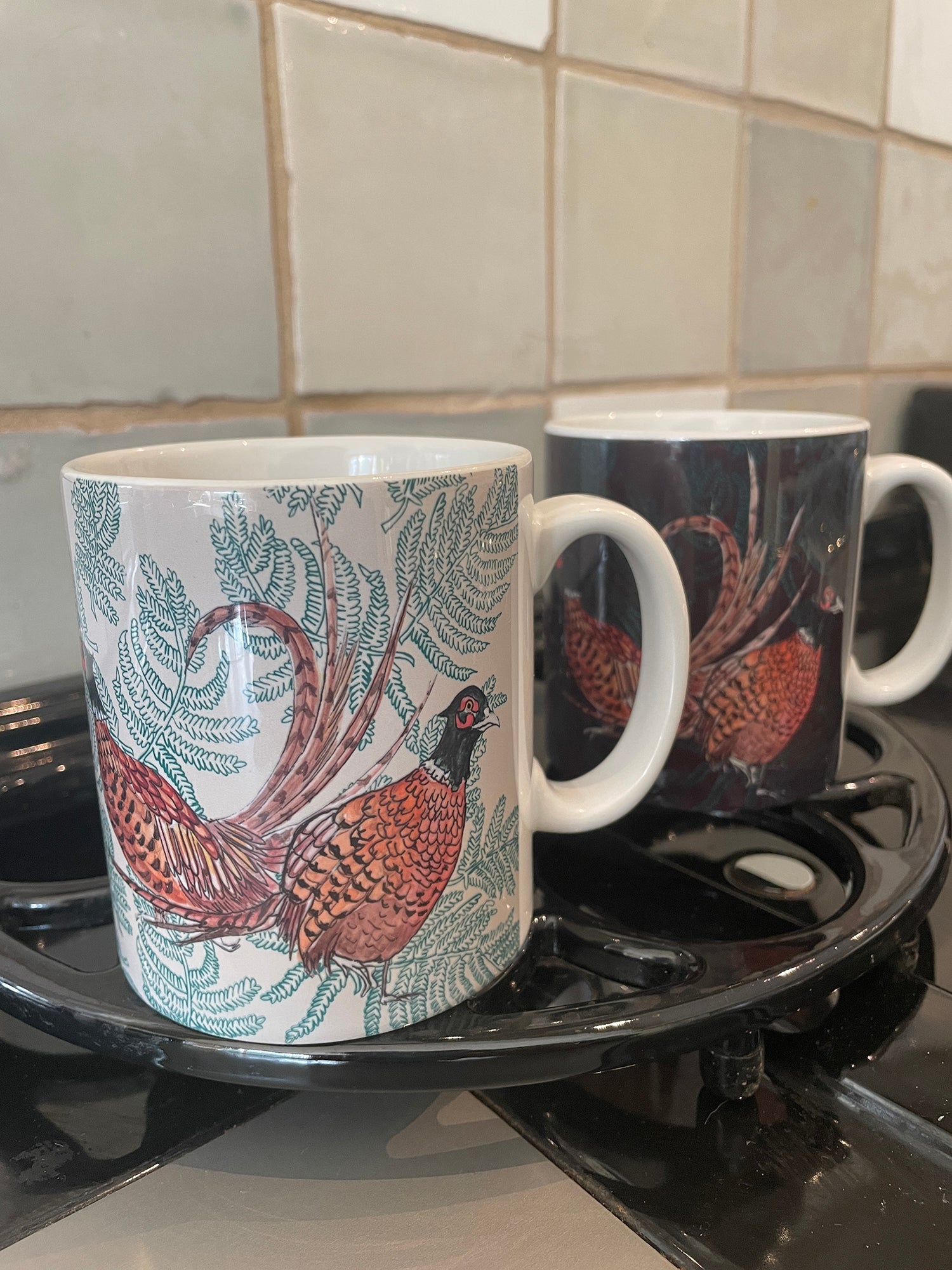 Beige and brown pheasant fern illustrated mugs on stove top