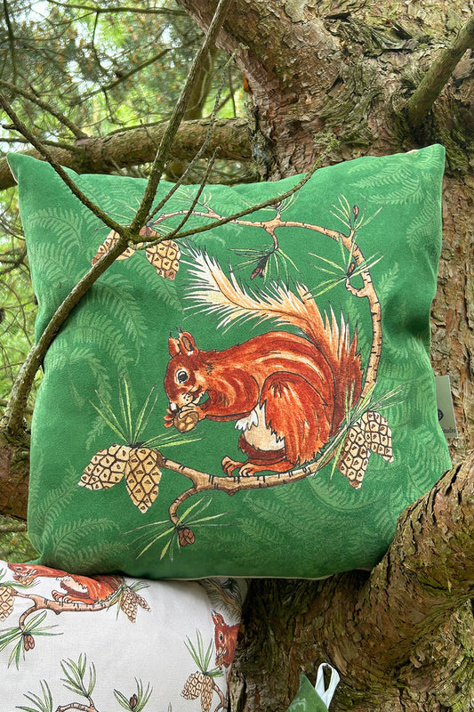 Illustration of red squirrel with fern background printed on a soft faux, suede green, cushion