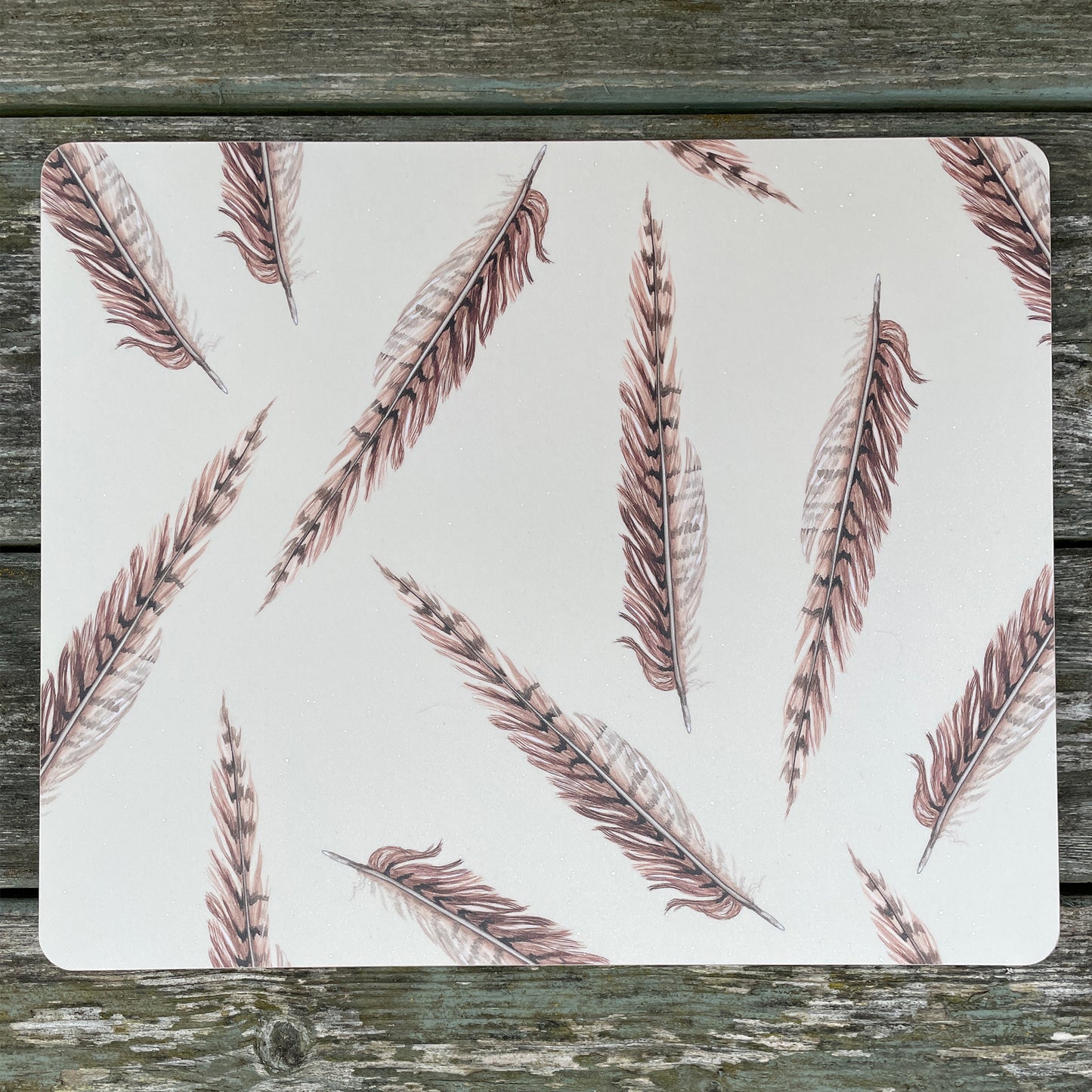 cream placemat with pheasant feather illustration