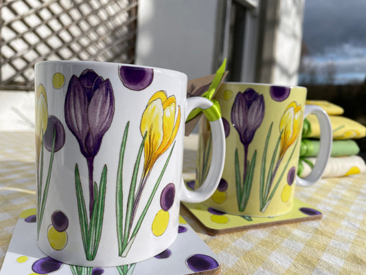 Crocus design mugs in white and yellow on coasters